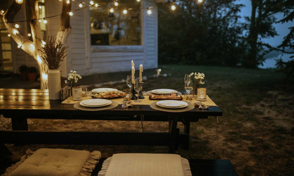 A candlelit celebration table set outdoors at dusk at Tipai