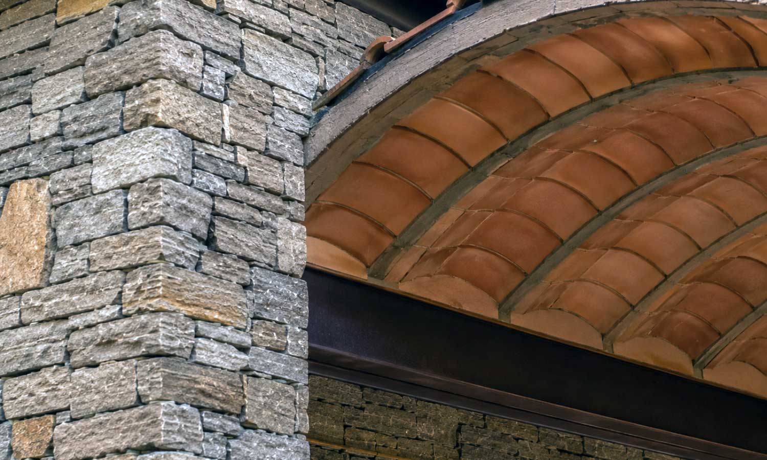 Stone masonry and vaulted terracotta roofing detail on a villa at Tipai