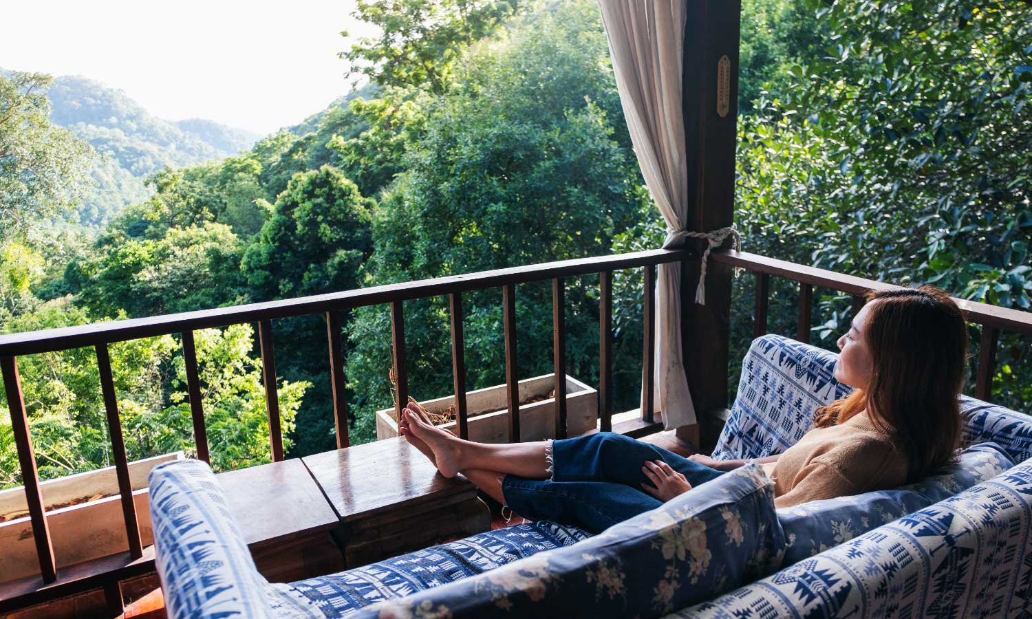 A woman enjoying the forest villa sit-out at Tipai, illustrating a natural digital detox